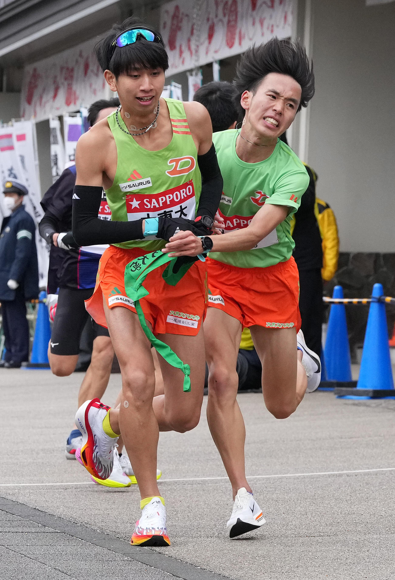 大東大6区小田（右）は7区宮倉に小田原中継所でたすきを渡す（撮影・鈴木みどり）