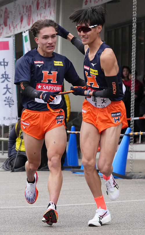 法大6区湯田（左）は7区宮岡に小田原中継所でたすきを渡す（撮影・鈴木みどり）