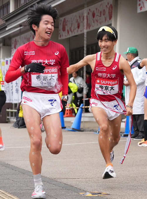 帝京大6区広田（左）は7区福田に小田原中継所でたすきを渡す（撮影・鈴木みどり）