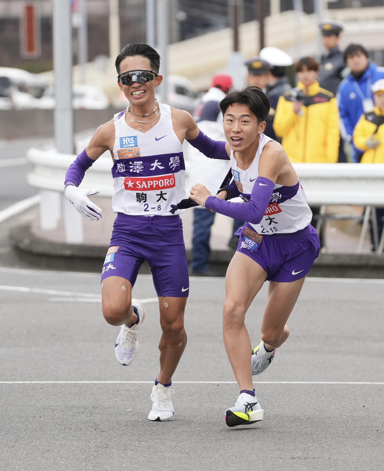 戸塚中継所でタスキリレーする駒大8区安原（左）と9区村上（撮影・垰建太）