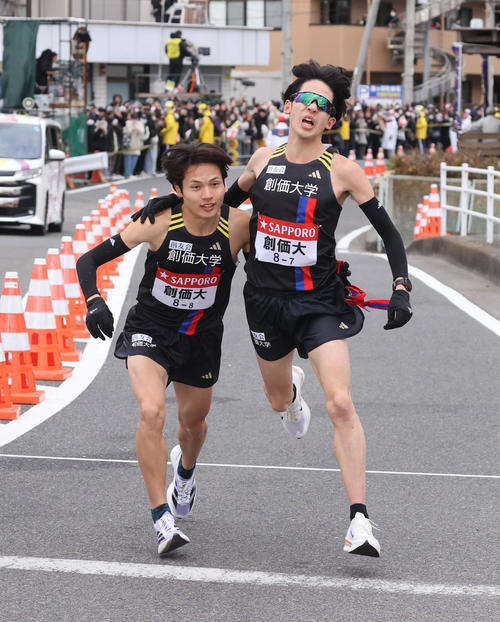 平塚中継所でタスキをつなぐ創価大7区の織橋巧（右）と創価大8区の石丸修那（代表撮影）