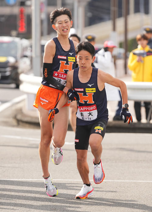 戸塚中継所でタスキリレーする法大8区安沢（左）と9区清水（撮影・垰建太）