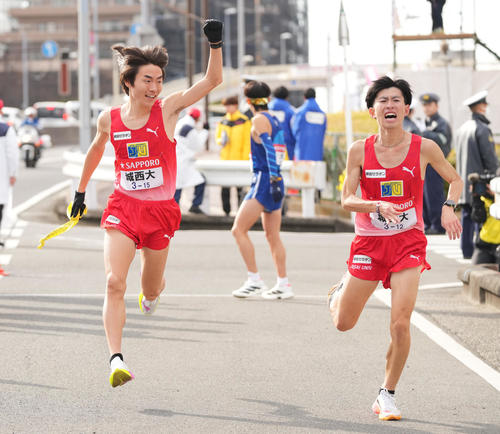 戸塚中継所でタスキリレーする城西大8区岩田（右）と9区桜井（撮影・垰建太）
