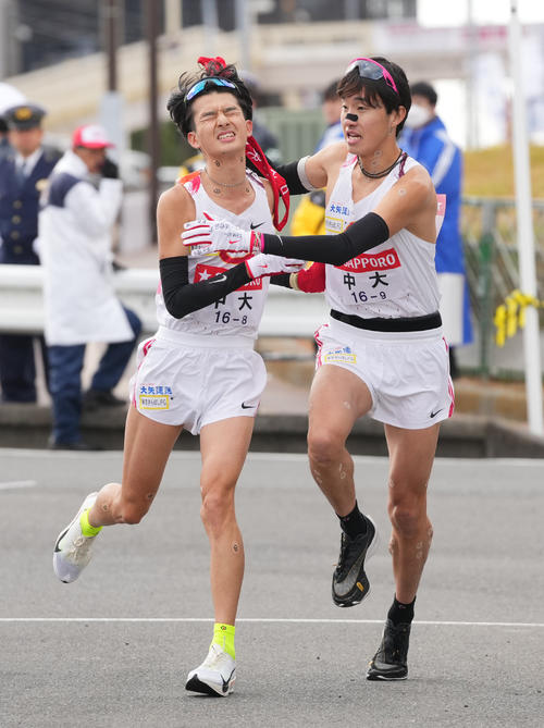 戸塚中継所でタスキリレーする中大8区佐藤（左）と9区吉中（撮影・垰建太）