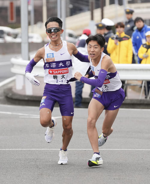 戸塚中継所でタスキリレーする駒大8区安原（左）と9区村上（撮影・垰建太）