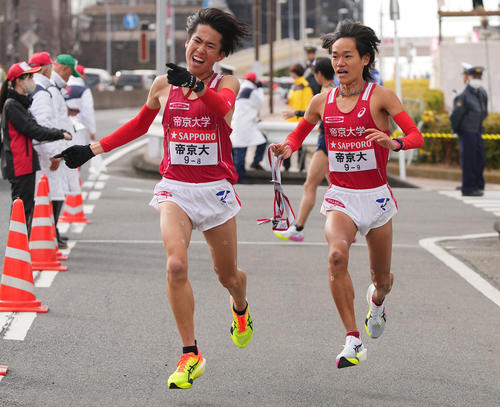 戸塚中継所でタスキリレーする帝京大8区高島（左）と9区小林（撮影・垰建太）