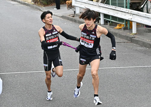 鶴見中継所でタスキリレーする国学院大の9区上原（左）と10区吉田（撮影・滝沢徹郎）