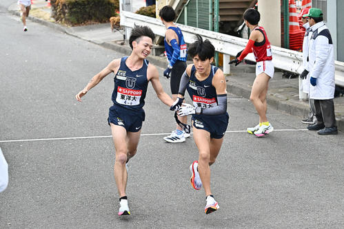 鶴見中継所でタスキリレーする東洋大の9区吉田（左）と10区薄根（撮影・滝沢徹郎）