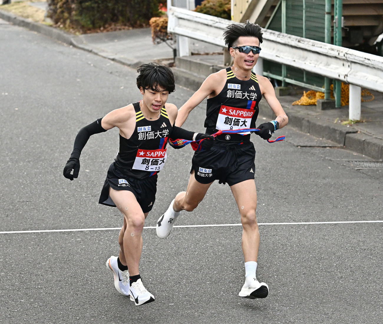 鶴見中継所でタスキリレーする創価大の9区吉田（右）と10区小池（撮影・滝沢徹郎）