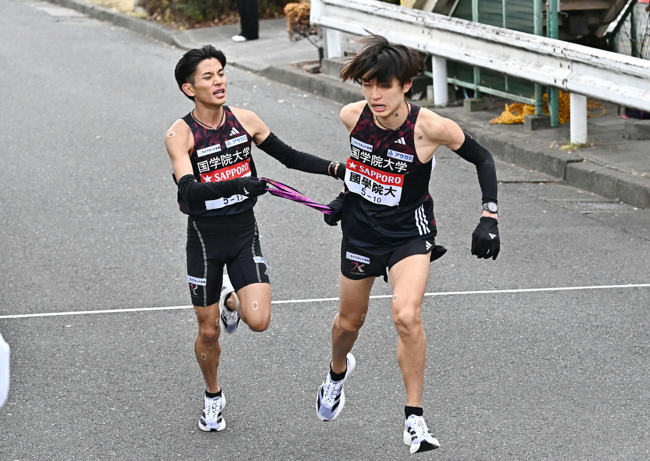 鶴見中継所でタスキリレーする国学院大の9区上原（左）と10区吉田（撮影・滝沢徹郎）