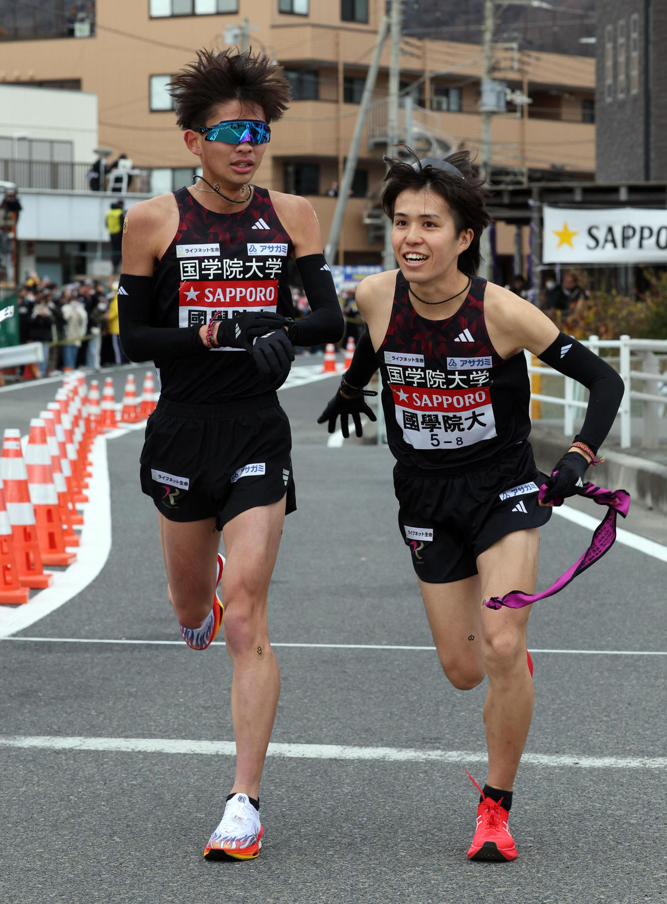 第101回箱根駅伝　復路　平塚中継所でたすきをつなぐ国学院大7区・辻原輝（左）と8区・佐藤快成（代表撮影）