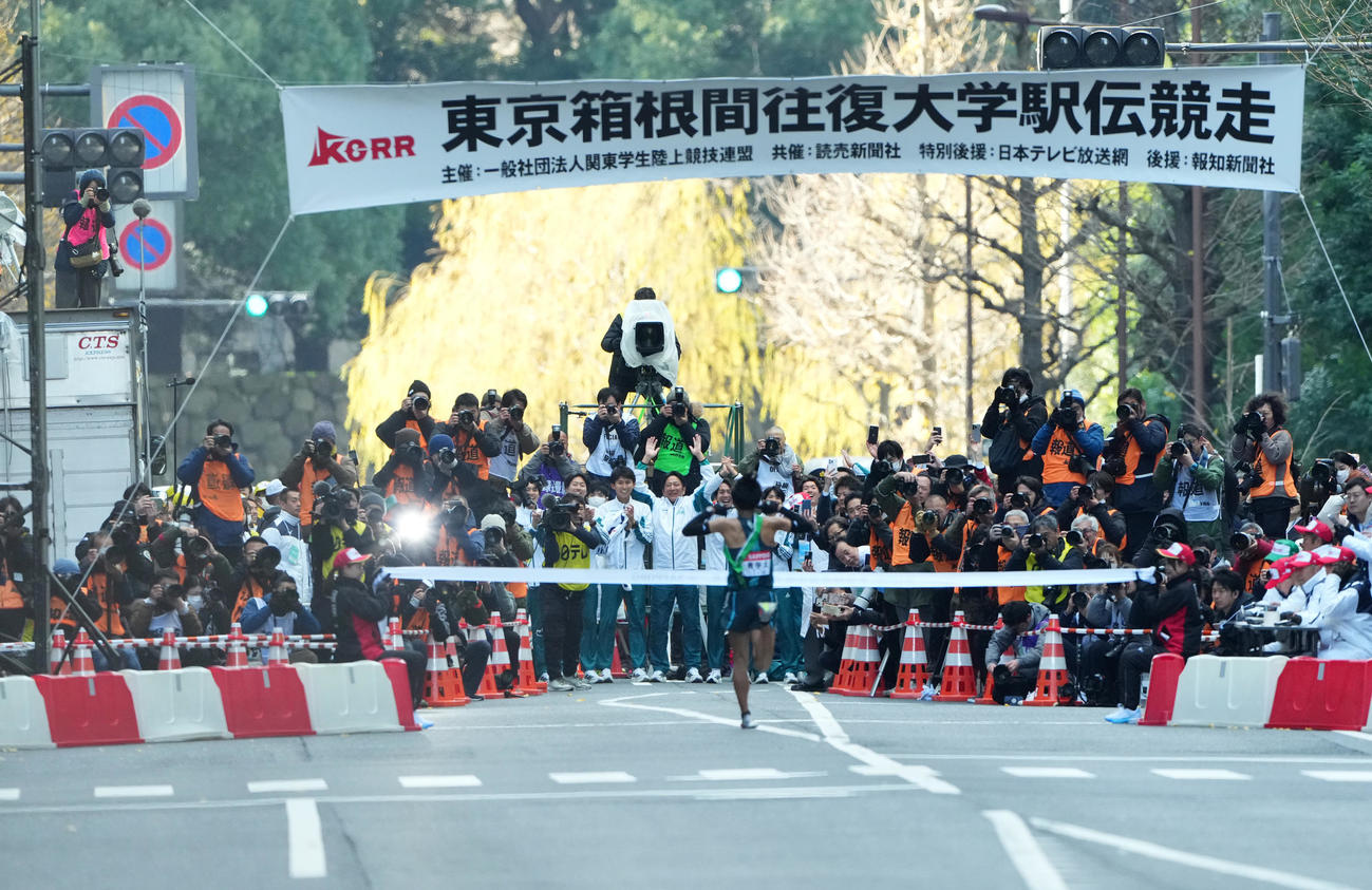 1位でゴールテープをきる青学大10区小河原（手前）を迎える原監督（中央）ら選手たち（撮影・菅敏）
