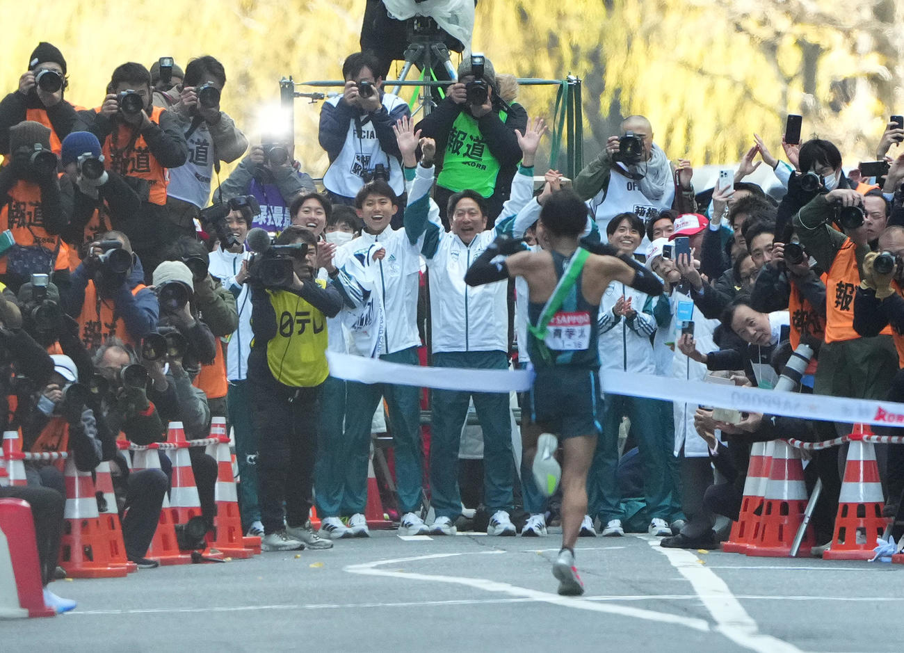 1位でゴールテープをきる青学大10区小河原陽琉を迎える原監督（中央）ら選手たち（撮影・菅敏）
