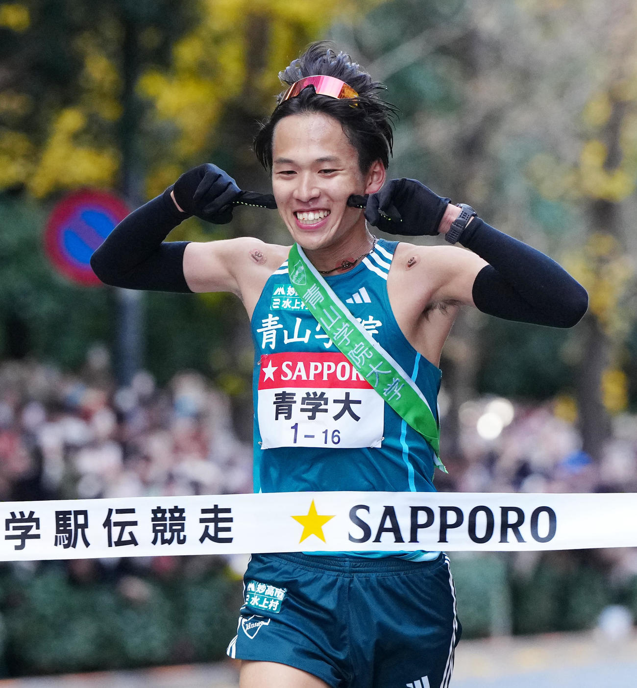 ポーズを決め、優勝テープに切る青学大10区小河原（撮影・江口和貴）