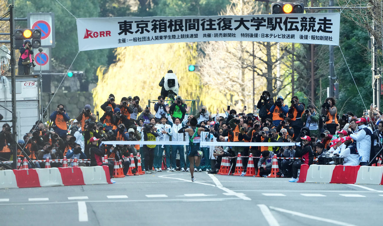 1位でゴールテープを切る青学大10区小河原（手前）を迎える原監督（中央）ら選手たち（撮影・菅敏）