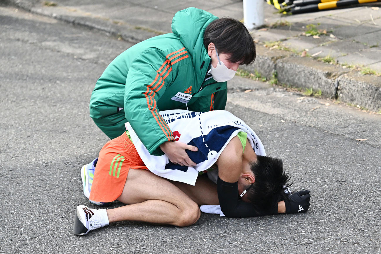 繰り上げスタート後に鶴見中継所にたどり着いた大東大9区大谷（下）はうずくまる（撮影・滝沢徹郎）