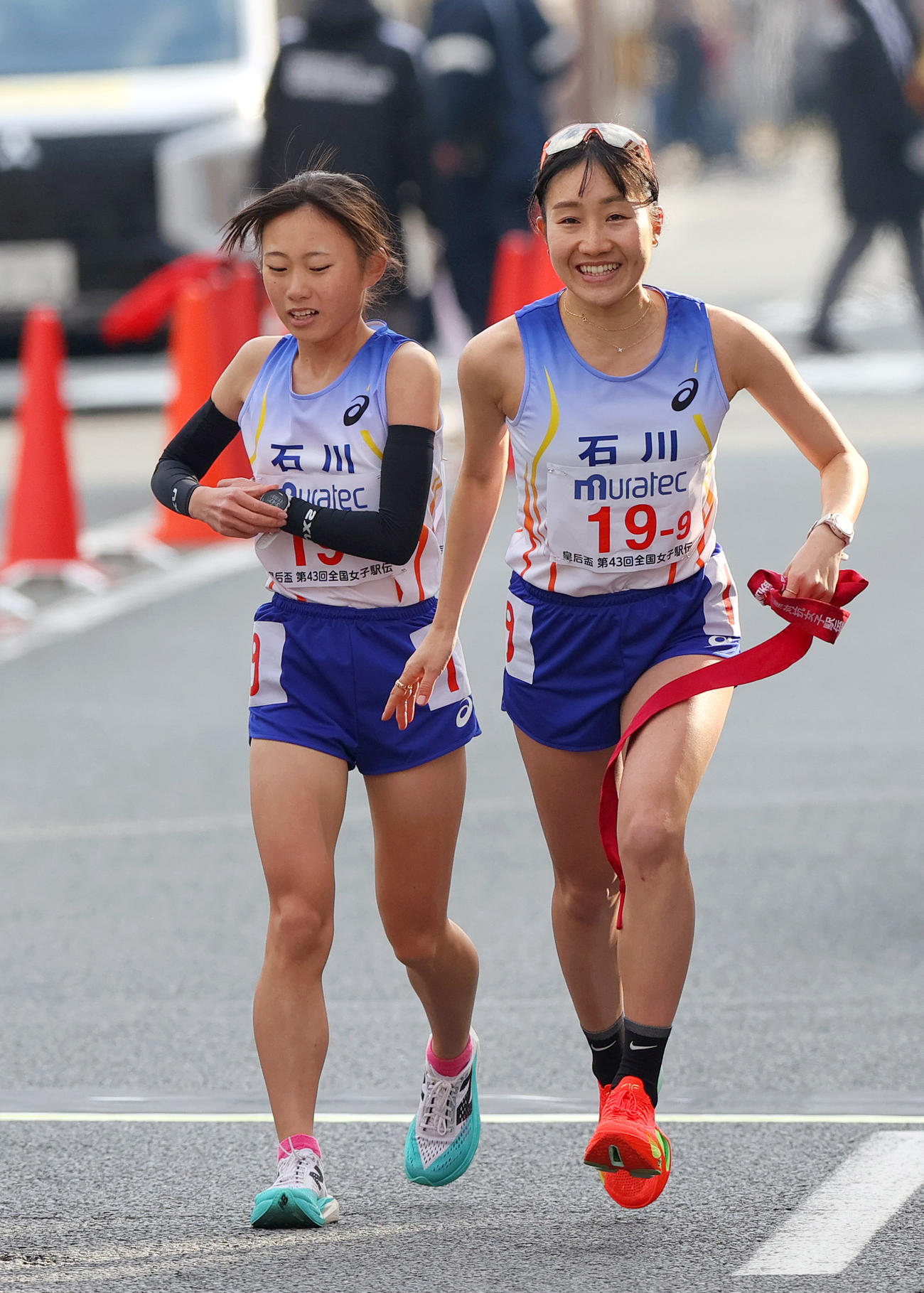 石川9区の五島莉乃（手前）は8区の松本咲希からタスキを受け走り出す（撮影・上山淳一）