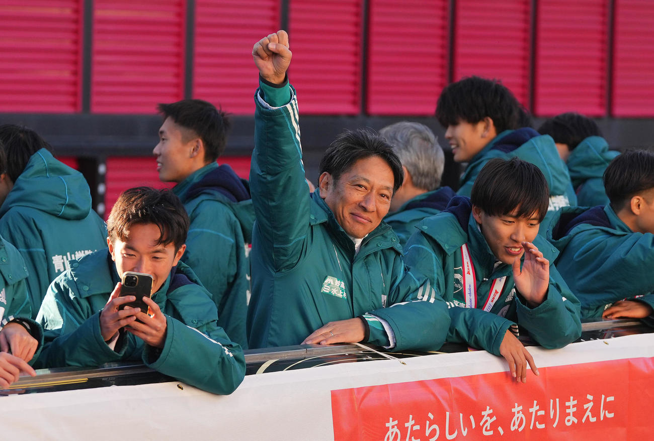 箱根駅伝優勝パレードのバスの上からポーズを決める青学大・原監督（中央）（撮影・垰建太）