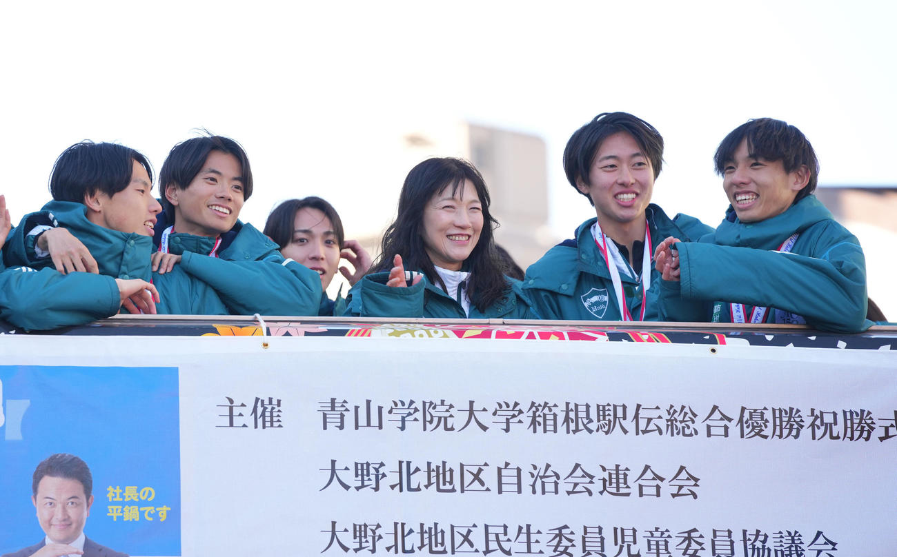 箱根駅伝優勝パレードで青学大の選手たちと笑顔を見せる原監督の妻美穂さん（中央）（撮影・垰建太）