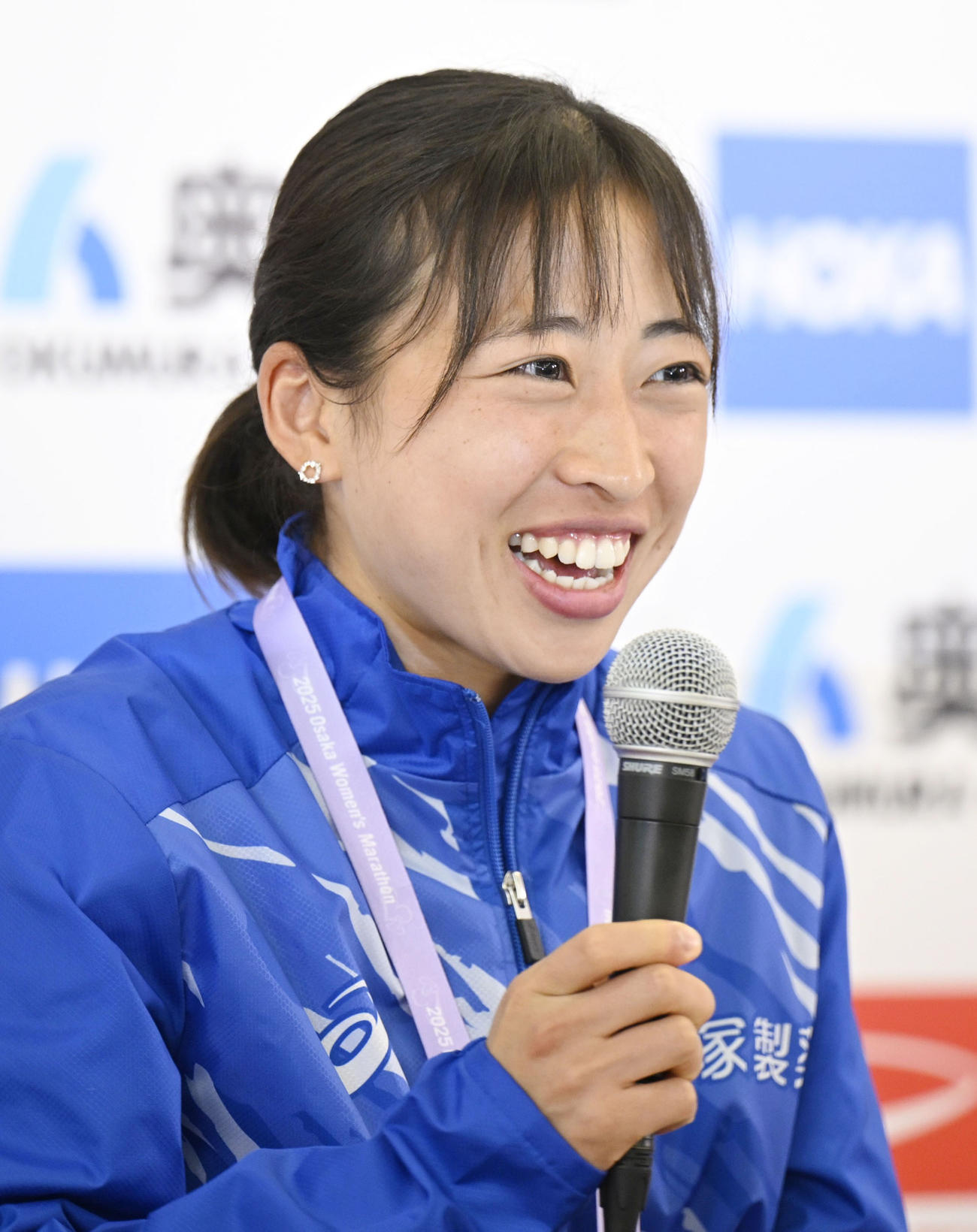 笑顔で記者会見する2位の小林香菜（共同）