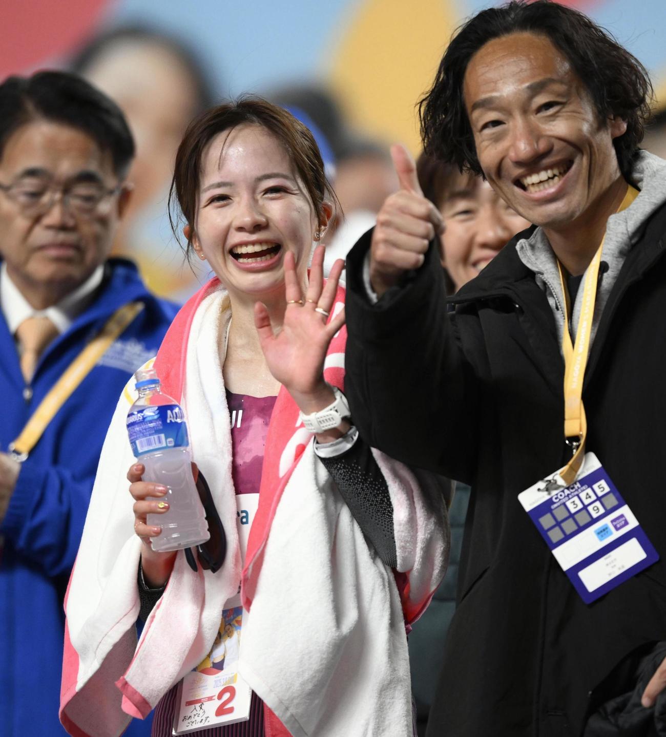 日本勢最高の2位でゴールし、笑顔の佐藤早也伽。右は積水化学の野口英盛監督（共同）