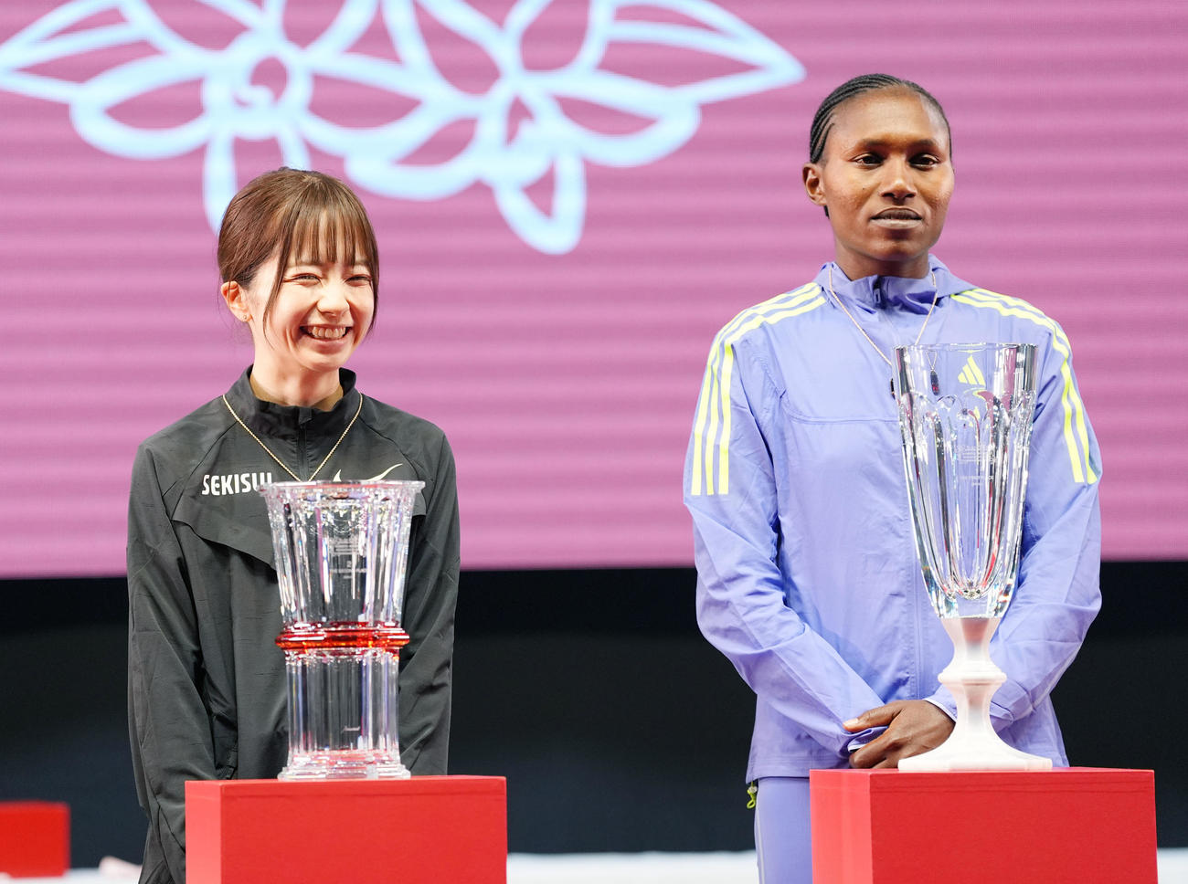 表彰式で笑顔を見せる佐藤早也伽（左）右は1位のシェイラ・チェプキルイ（撮影・森本幸一）