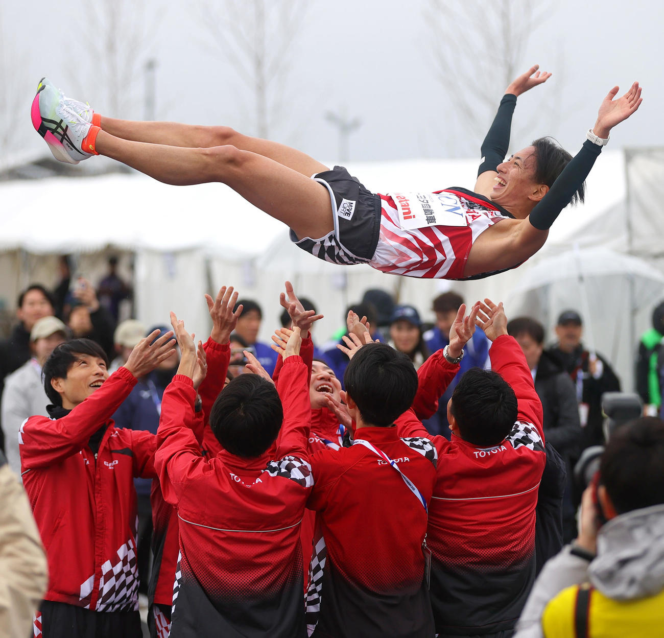 万博駅伝で優勝し、トヨタ自動車アンカー内田（上）を胴上げする選手ら（撮影・上山淳一）
