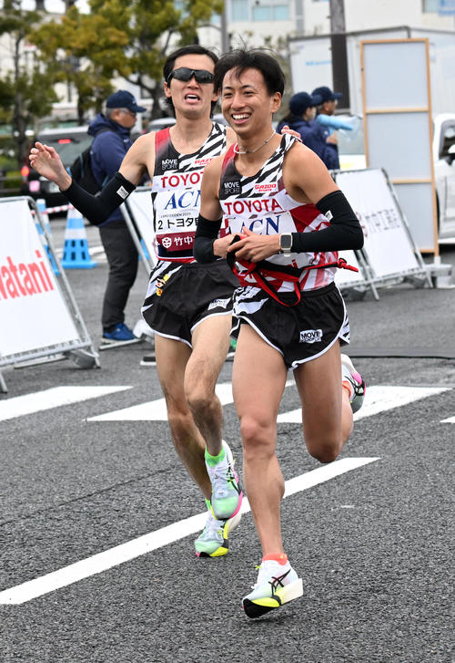 第6中継所、トヨタ自動車・田中（左）から首位でタスキを受け取る内田（撮影・前岡正明）