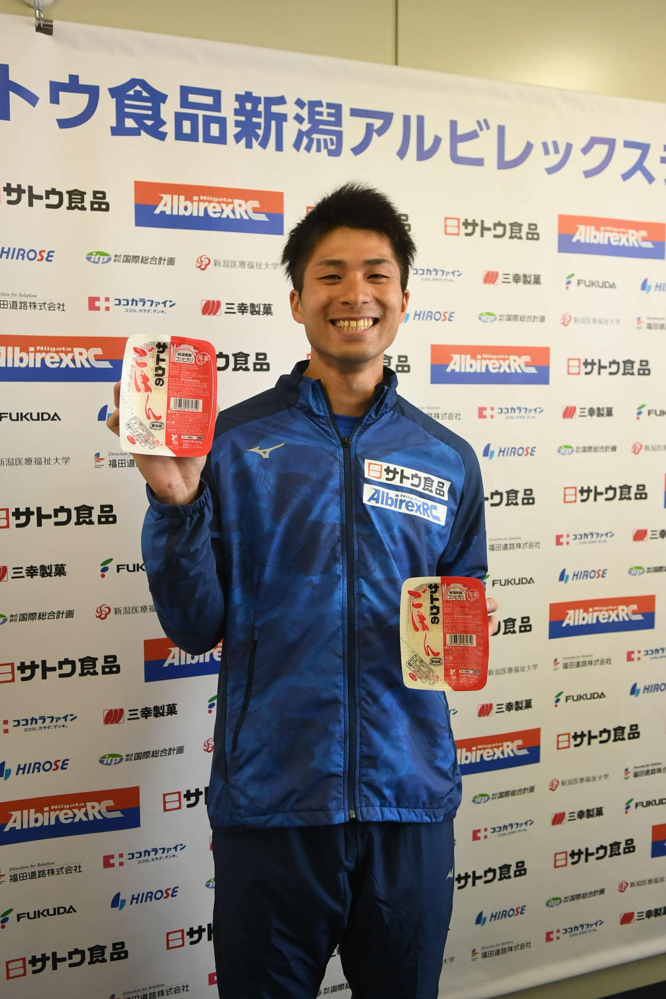 サトウ食品の人気商品「サトウのごはん」を手に笑顔で健闘を誓う長谷川