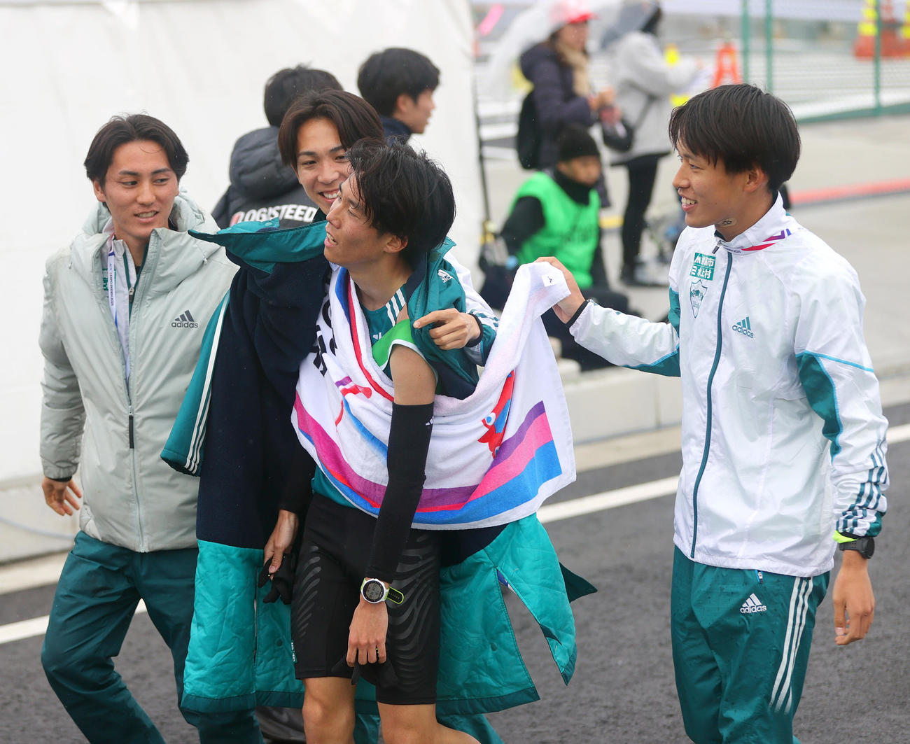 7位でゴールした青学大・アンカー中村（左から3人目）は仲間から迎えられる（撮影・上山淳一）