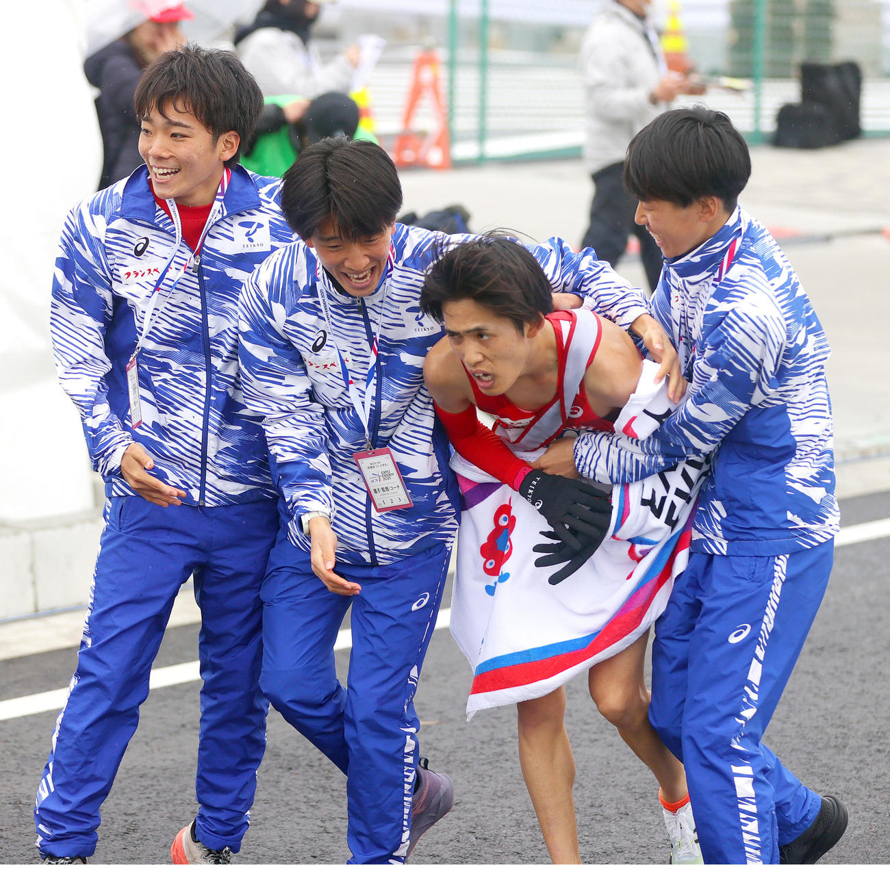 4位でゴールした帝京大・アンカー浅川（左から3人目）を笑顔で抱きかかえる選手ら（撮影・上山淳一）