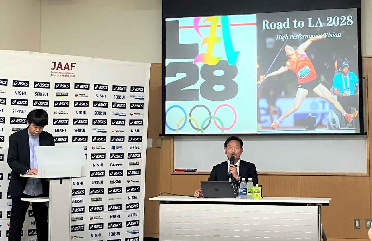 日本陸連強化方針会見で説明する山崎一彦強化委員長。スクリーンに投影されているのは女子やり投げの北口榛花（撮影・藤塚大輔）