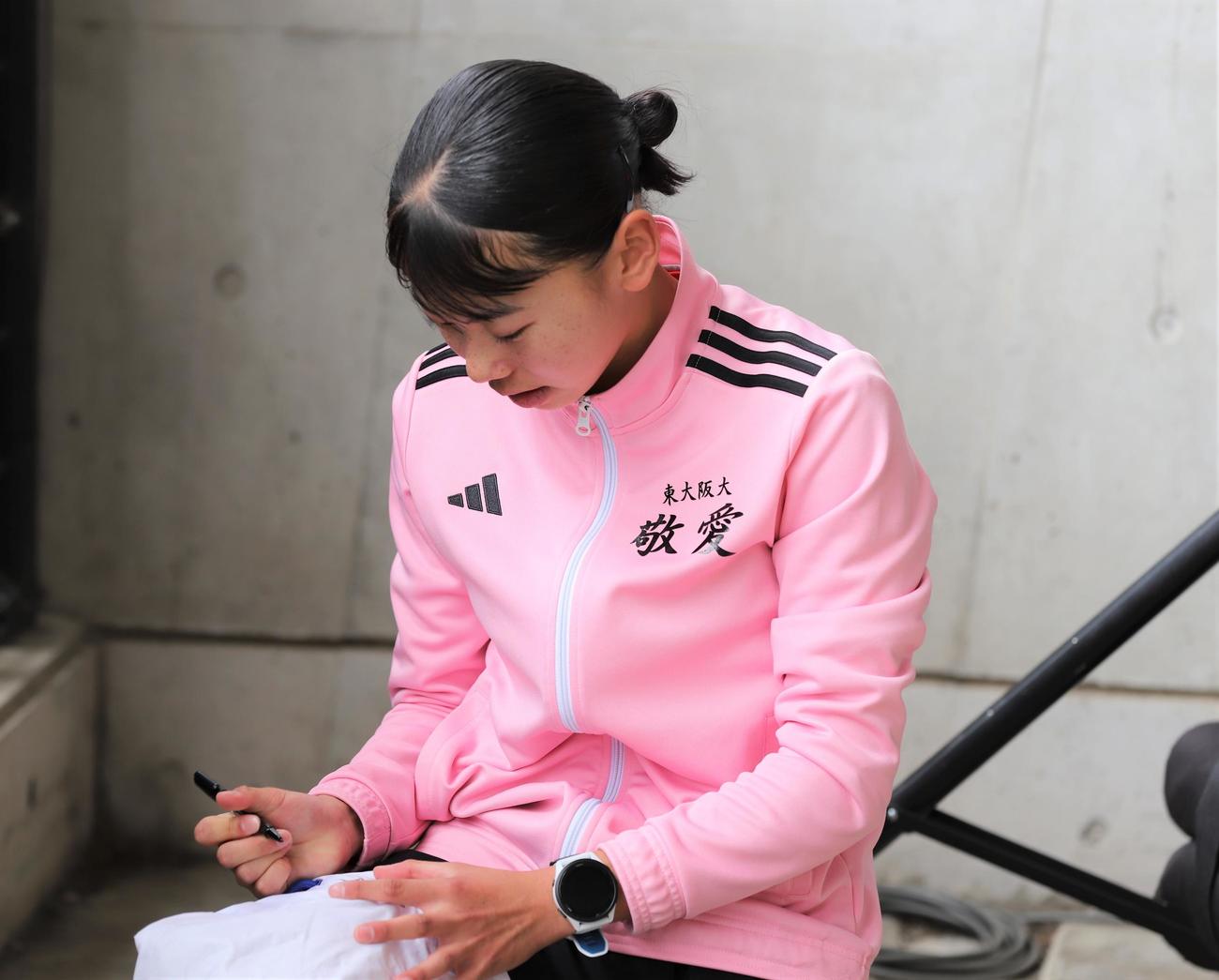 金栗記念選抜陸上中長距離大会　女子800メートルのレース後に子どもたちからのサインに応じる久保凛（撮影・藤塚大輔）