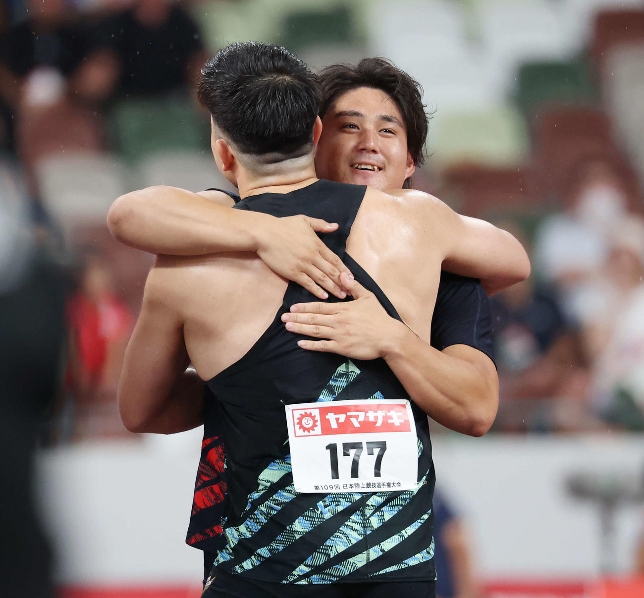 男子やり投げ決勝　87メートル16を記録しディーン（手前）とハグする崎山（撮影・宮地輝）