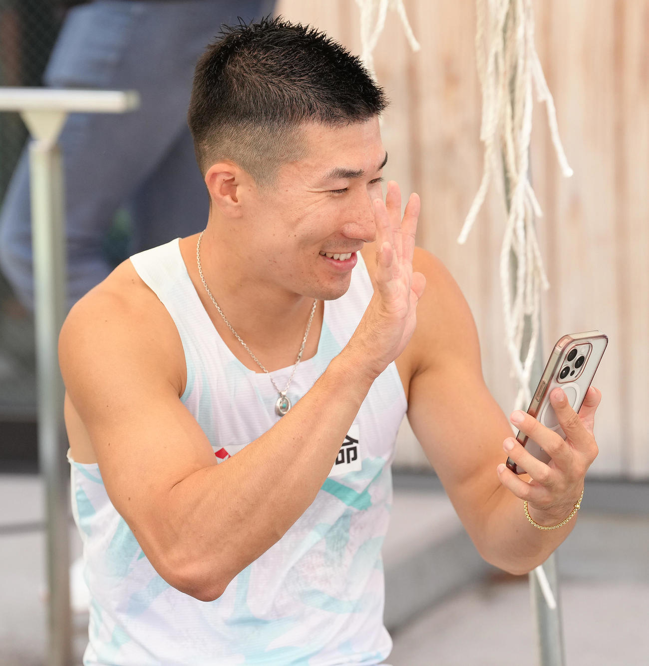 男子100メートル予選で9秒99をマークした桐生は電話で喜びの報告をする（撮影・足立雅史）