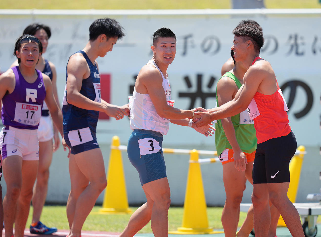 男子100メートル予選で9秒99をマークし、同組の選手から祝福に笑顔を見せる桐生（右から2人目）（撮影・足立雅史）