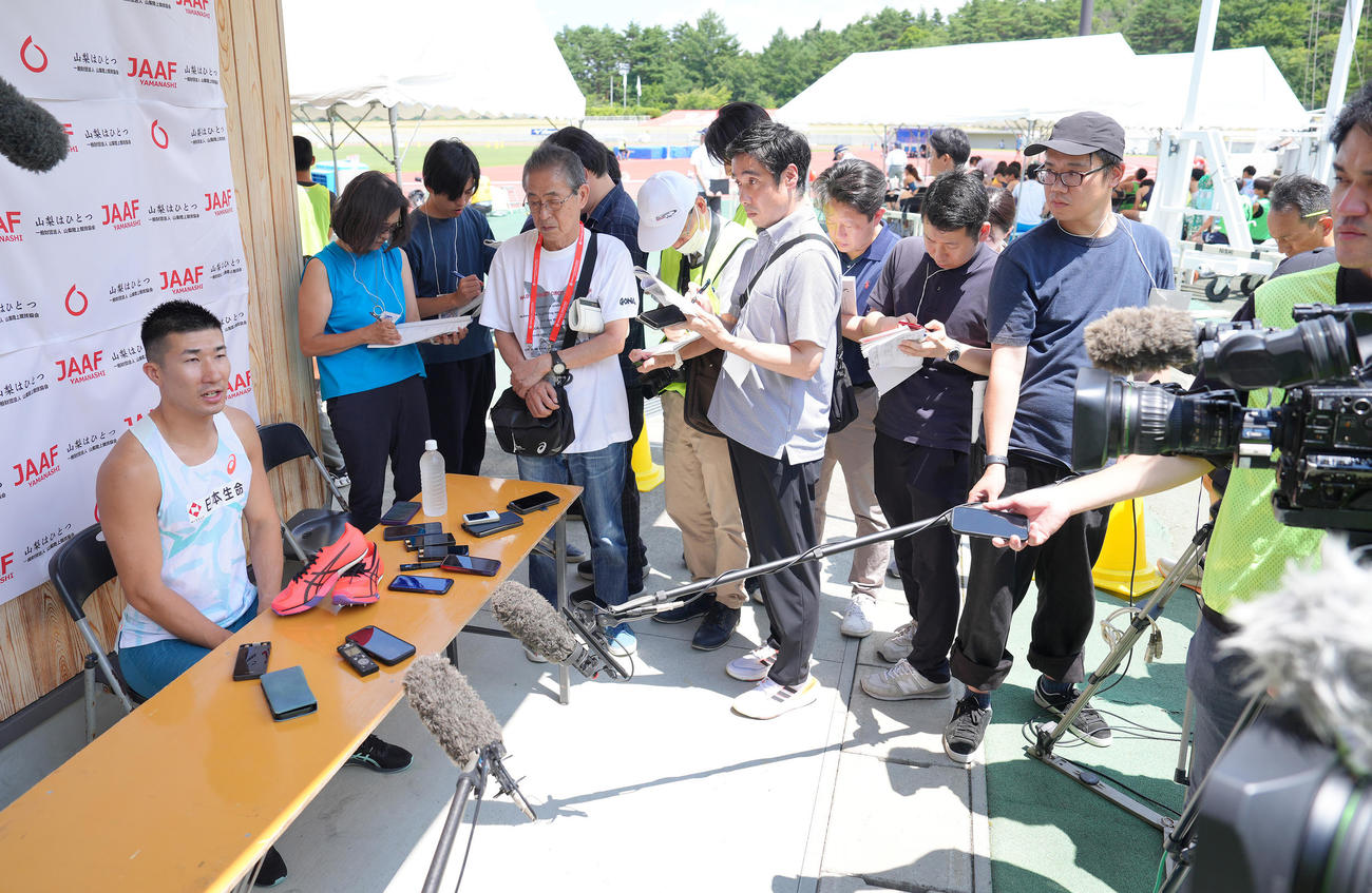 多くの報道陣に囲まれながら取材に応じる桐生（撮影・足立雅史）