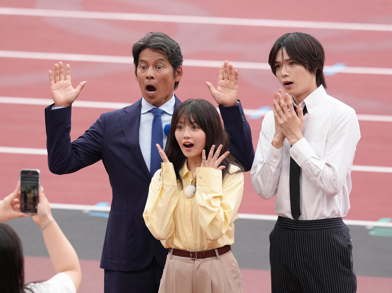撮影で驚きの表情を見せる、左から織田裕二、今田美桜、＆TEAMのK（撮影・足立雅史）