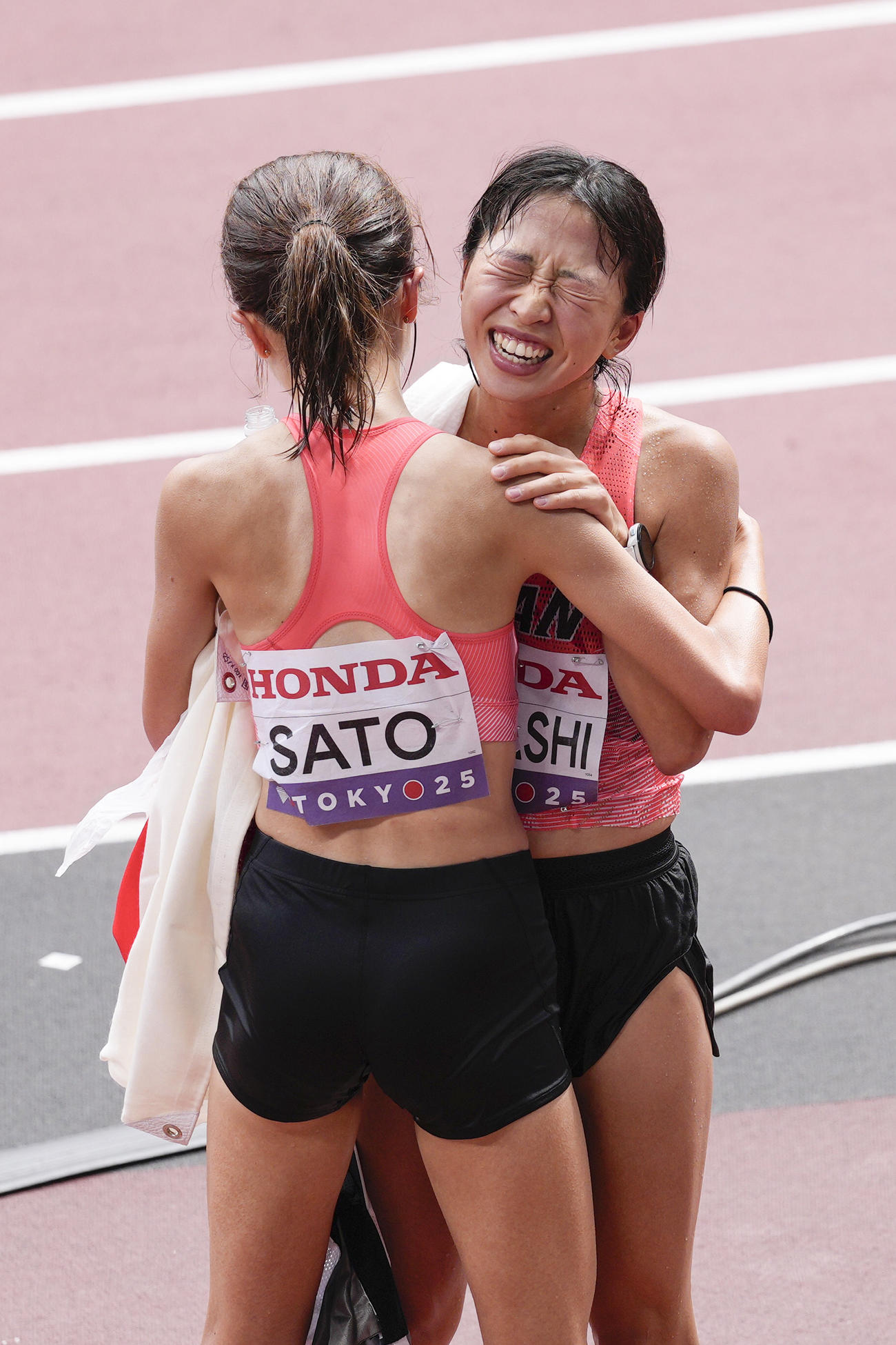 女子マラソン　レース後、佐藤早也伽（手前）と健闘をたたえ合う小林香菜（共同）