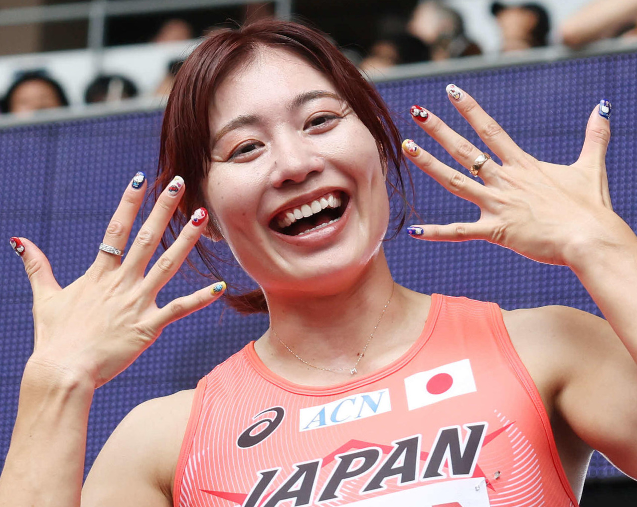 女子100メートル障害予選　準決勝進出を決め笑顔でネイルを披露する福部（撮影・宮地輝）