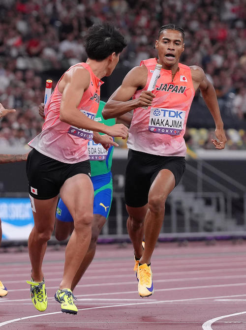 1600メートルリレー予選　バトンリレーに手間取る一走中島（右）と二走佐藤（撮影・足立雅史）