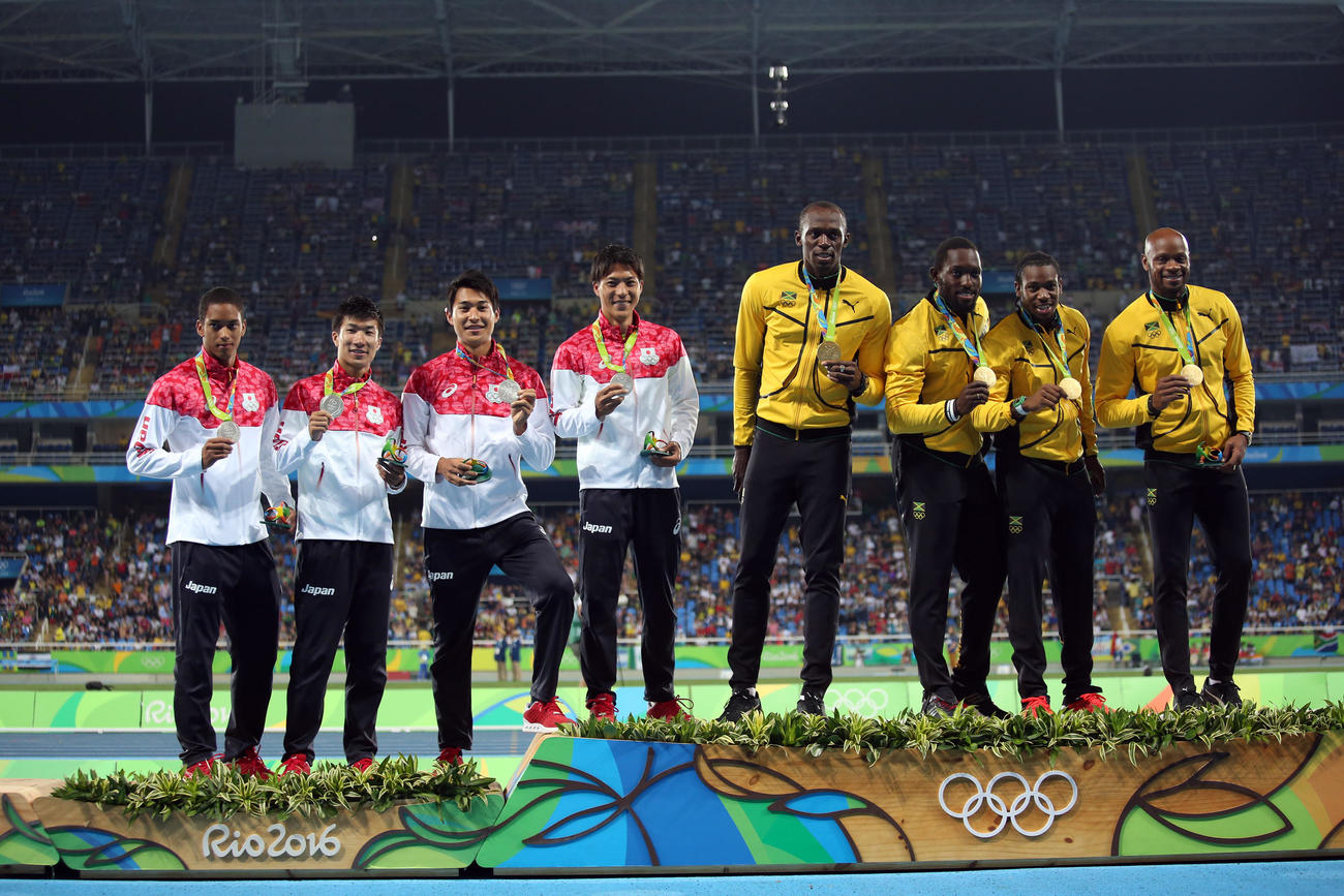 2016年8月　リオデジャネイロ五輪　陸上男子400メートルリレー表彰式　表彰台上がる日本リレーメンバー、左からケンブリッジ飛鳥、桐生祥秀、飯塚翔太、山県亮太。同5人目からジャマイカのウサイン・ボルト、ニケル・アシュミード、ヨハン・ブレーク、アサファ・パウエル