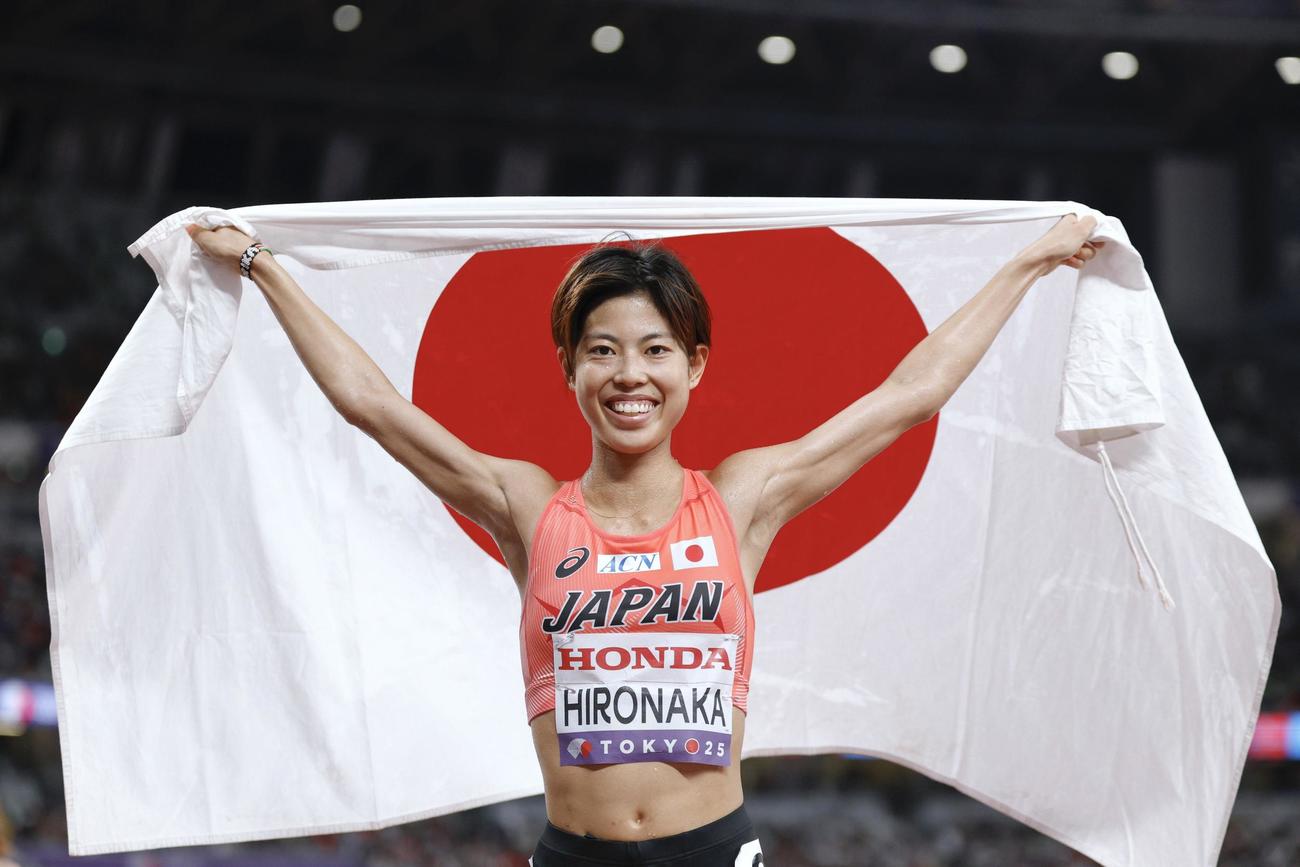 女子1万 メートル 　6位入賞を果たし、日の丸を掲げる広中璃梨佳（共同）
