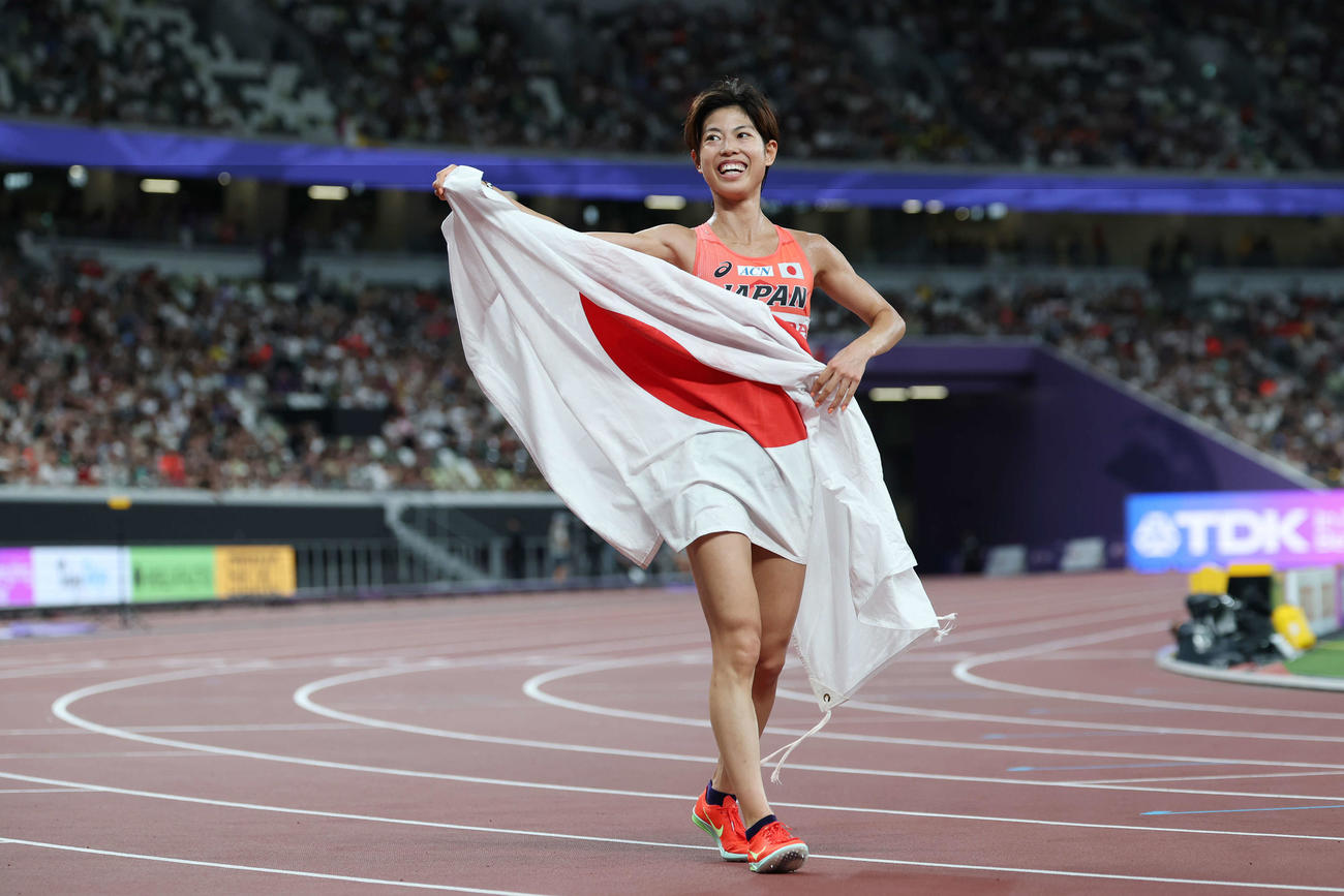 女子10000メートル　レース後、日の丸を手に笑顔の広中（撮影・宮地輝）