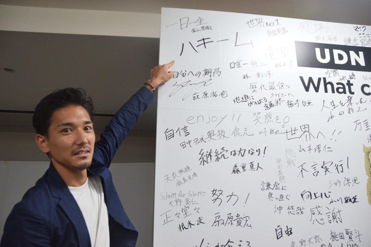 サニブラウンの直筆サインを指さすUDN SPORTSの井上雄太マネジャー