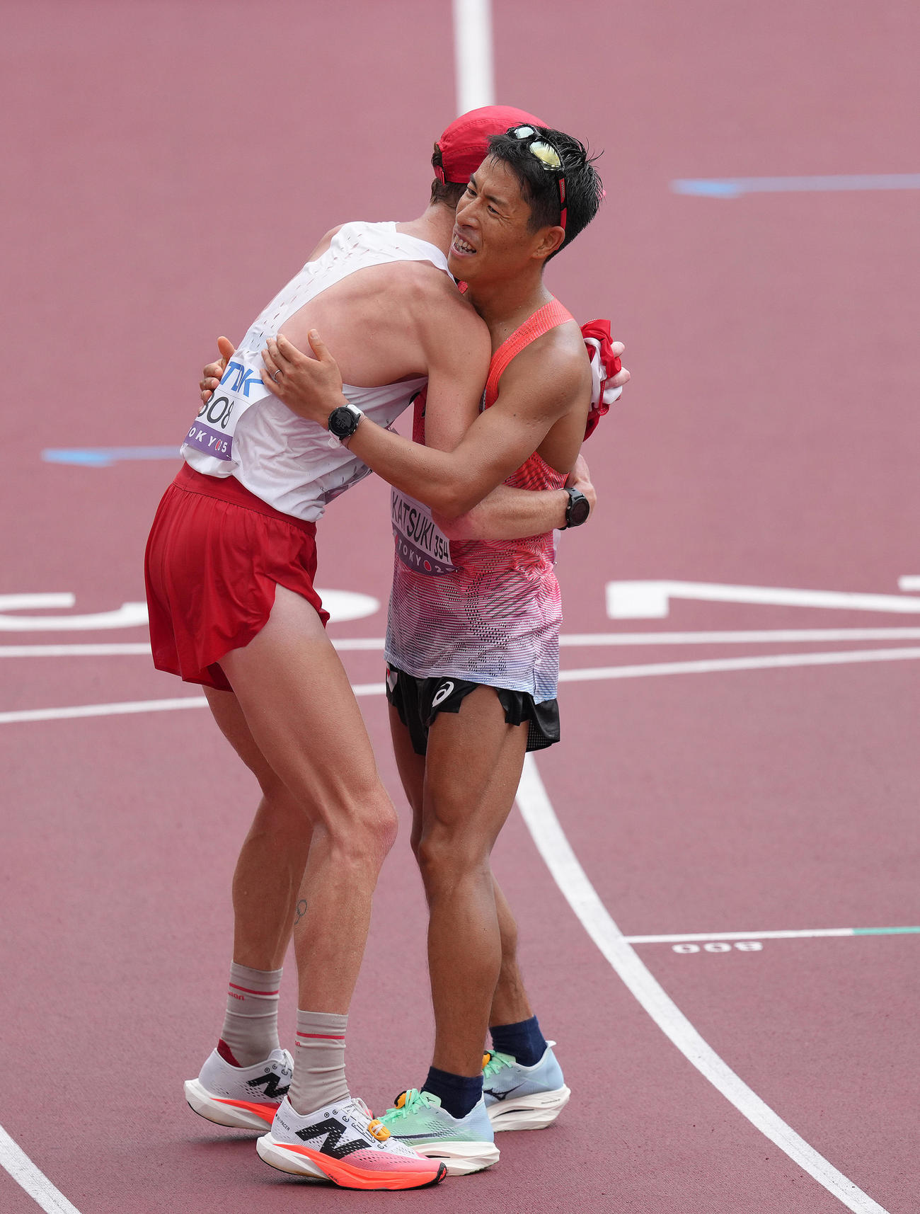 男子35キロ競歩決勝で銅メダルを獲得した勝木（右）は金メダルのカナダのダンフィーと抱き合い健闘をたたえ合う（撮影・足立雅史）