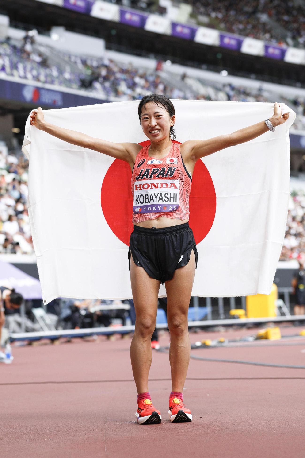 女子マラソン　7位入賞を果たし、日の丸を掲げる小林香菜（共同）