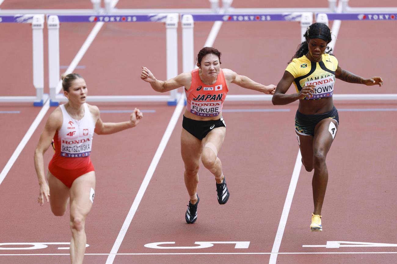 女子100メートル障害予選　ゴールする福部真子（中央）（共同）