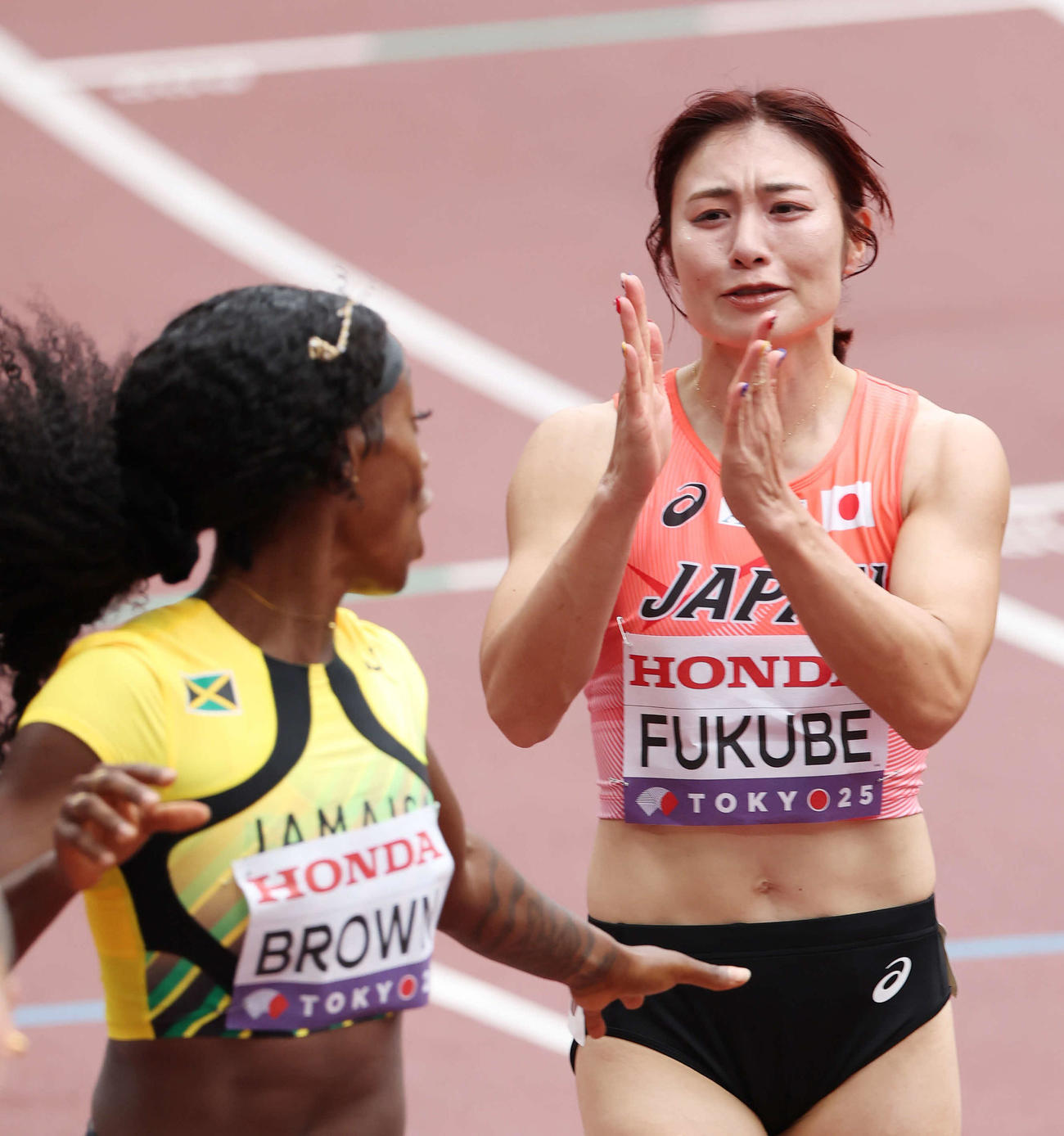 女子100メートル障害予選　レース後、ジャマイカのブラウン（左）と交錯しそうになり謝る福部（撮影・宮地輝）