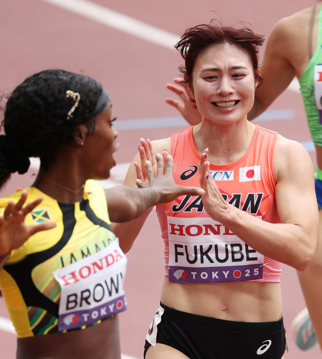 女子100メートル障害予選　レース後、ジャマイカのブラウン（左）と交錯しそうになり謝る福部（撮影・宮地輝）